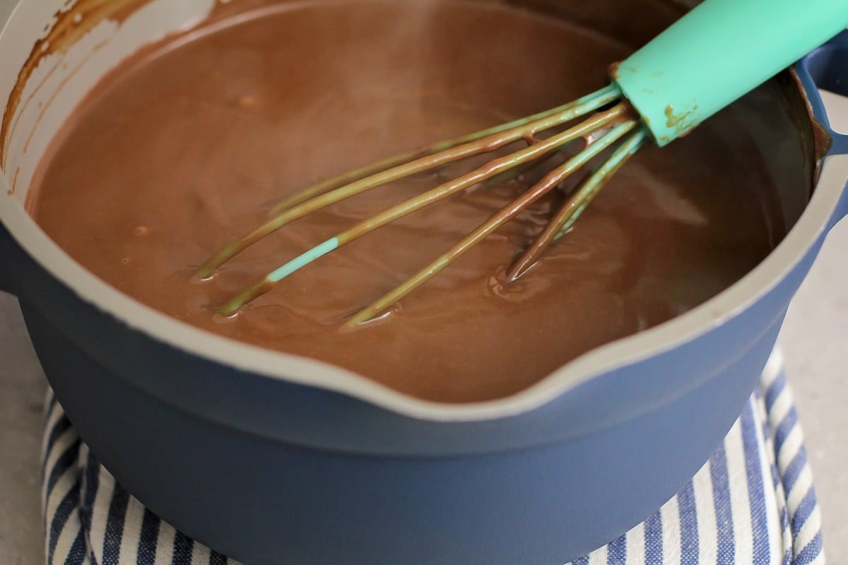 Whisking a chocolate mixture in a blue pot.