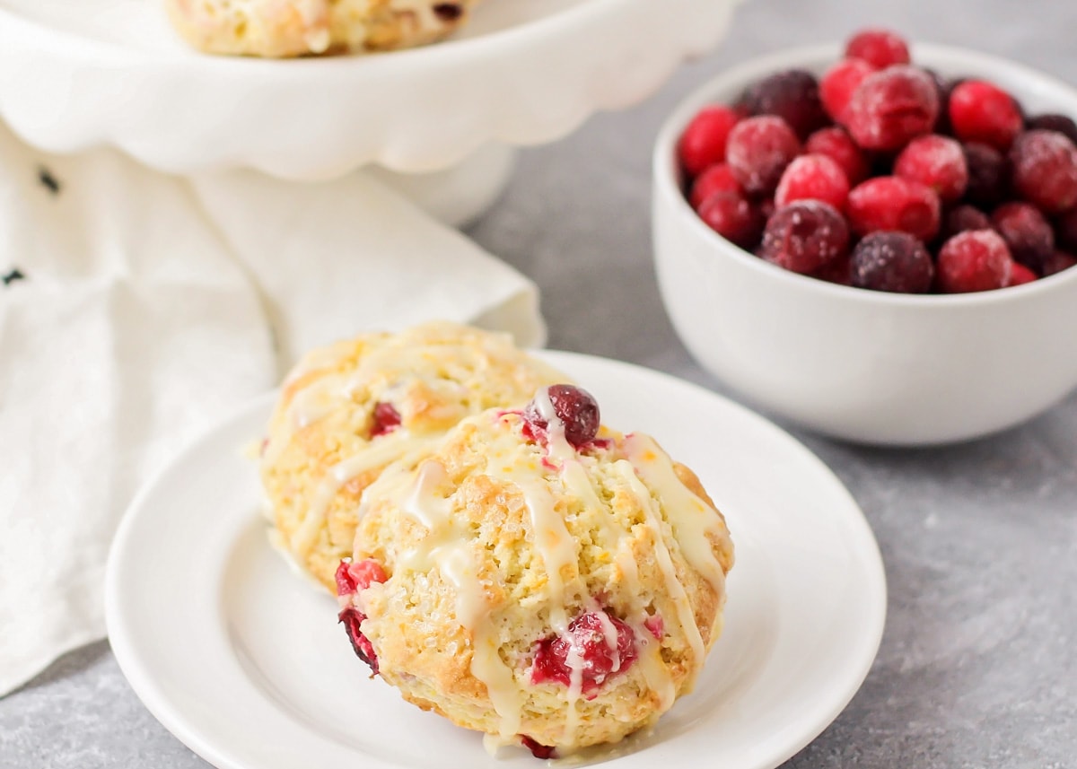 Two cranberry orange scones topped with an orange glaze.