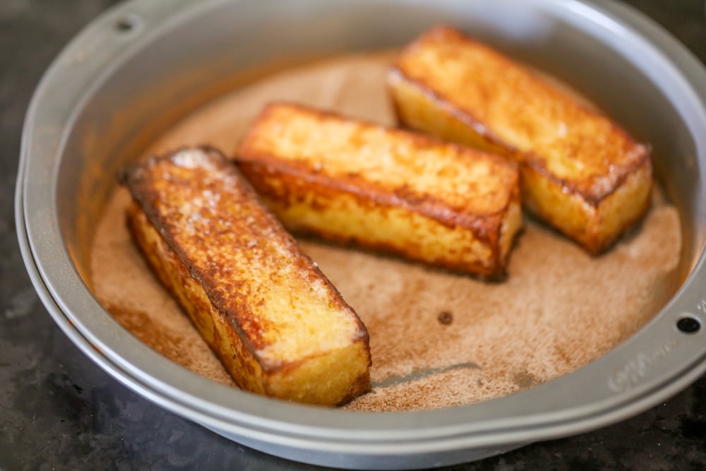 Cooked French toast sticks coated in cinnamon and sugar mixture.