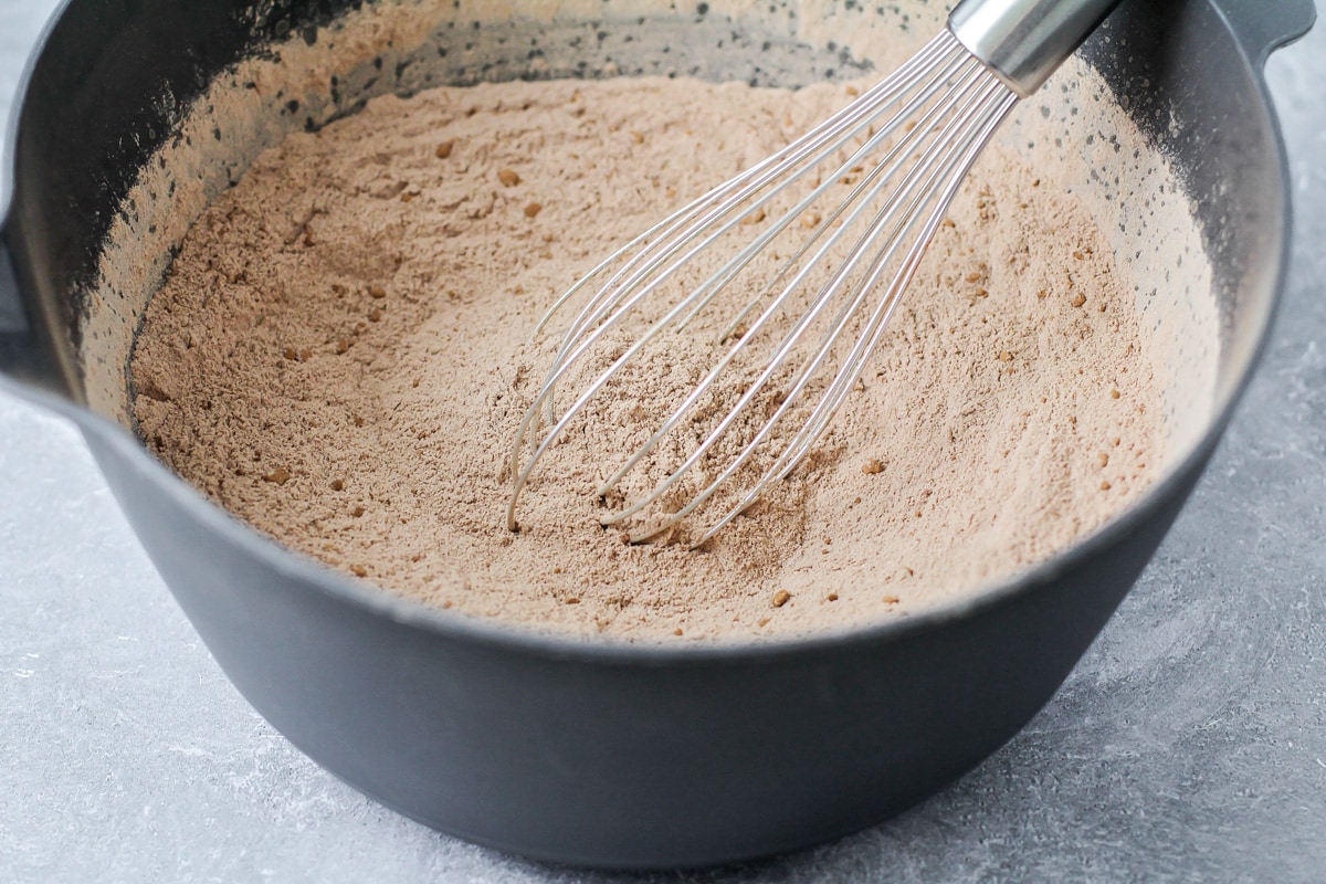 Dry ingredients mixed in a grey bowl to make chocolate cake.