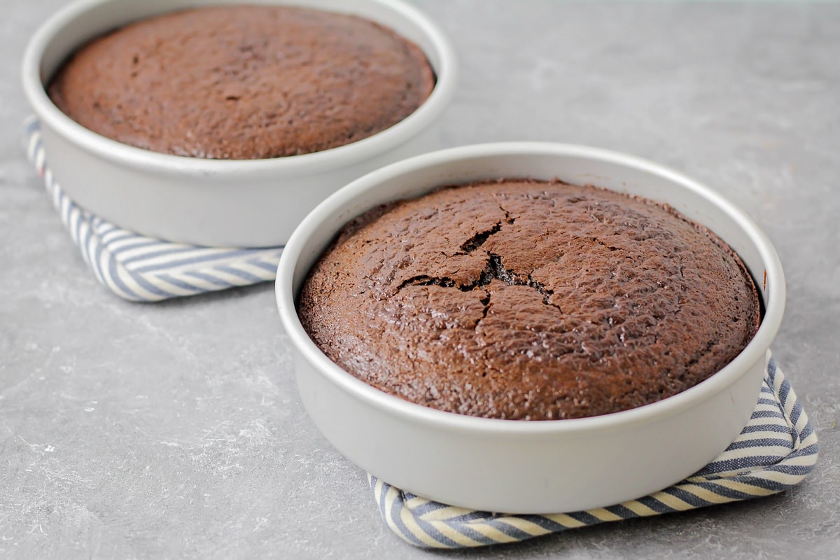 Two round chocolate cakes baked and cooling.