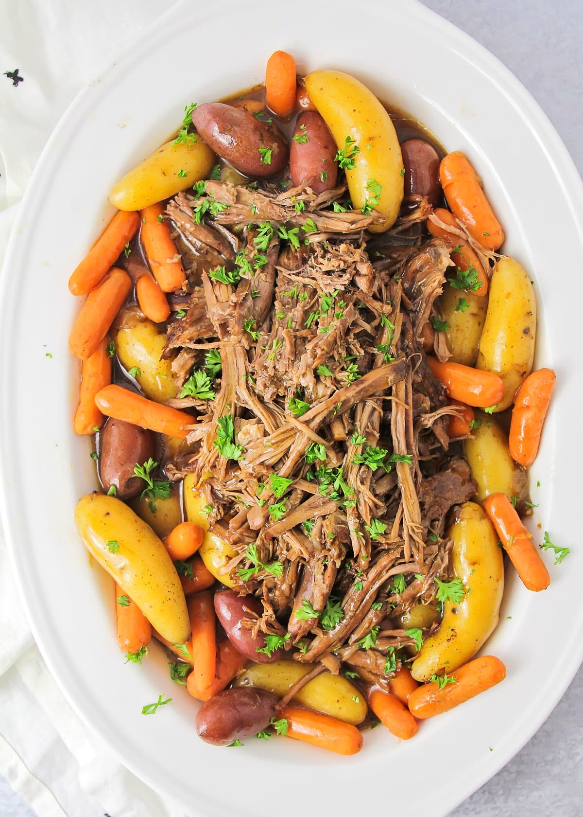 A platter filled with instant pot pot roast, carrots, and potatoes.