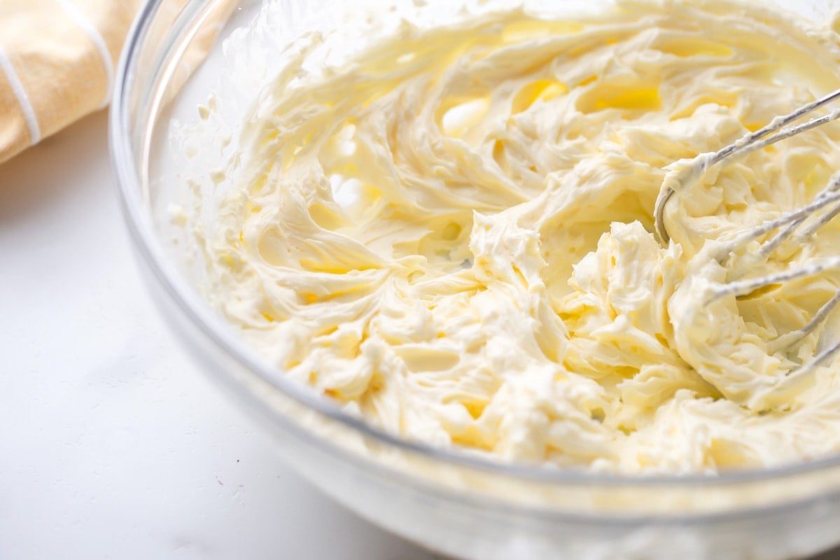 Whipping up butter and cream cheese in a glass bowl.