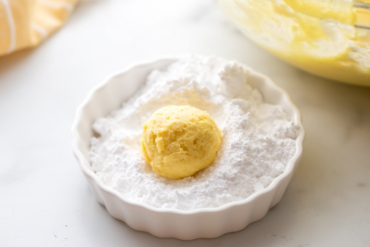 Covering lemon cookie dough with powder sugar.