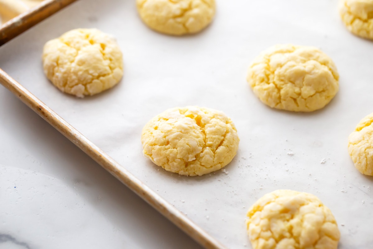 Baked lemon cookies on a lined cookie sheet.