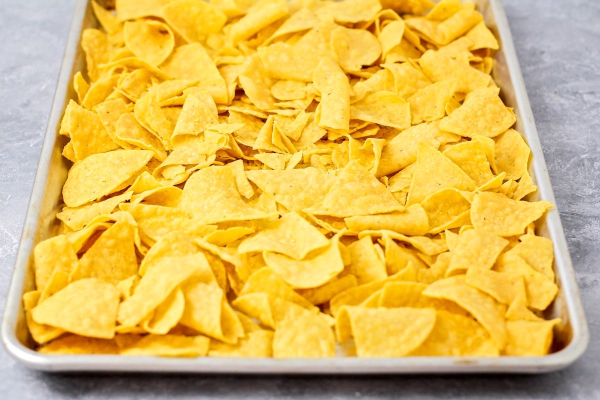 A sheet pan covered with tortilla chips.