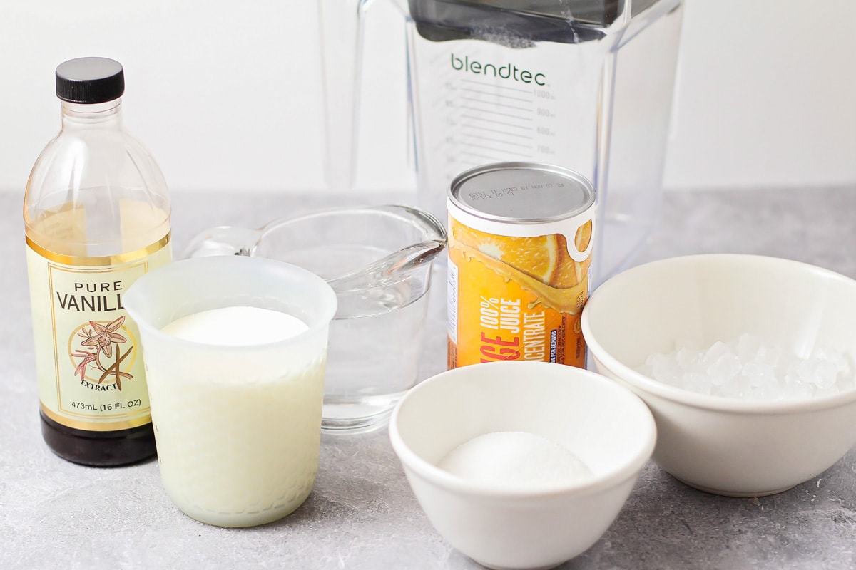 Orange Julius ingredients on a marble countertop.