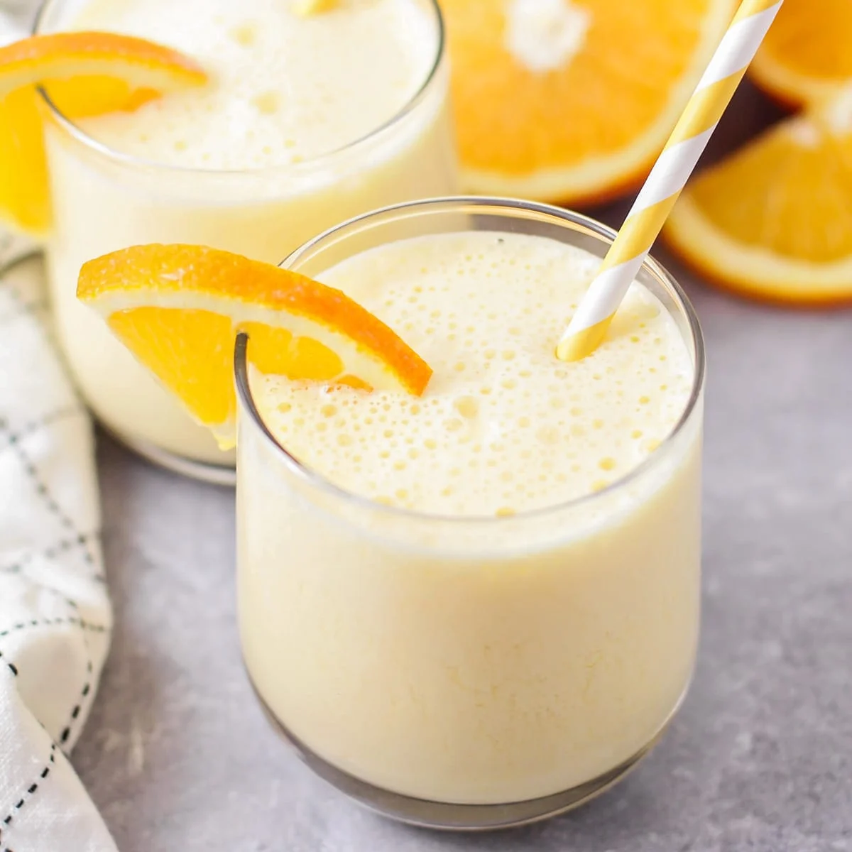 Orange julius served in a glass with fresh orange slice.