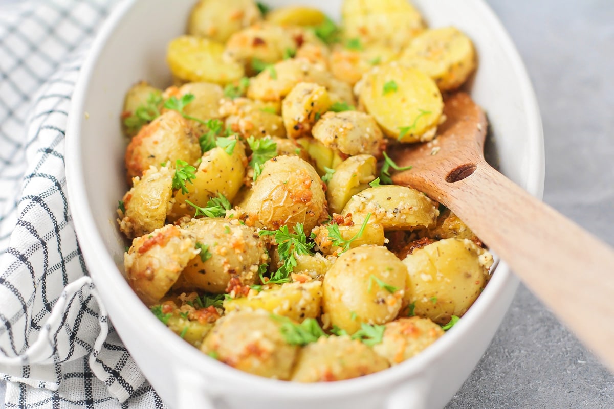 A white baking dish filled with parmesan crusted potatoes.