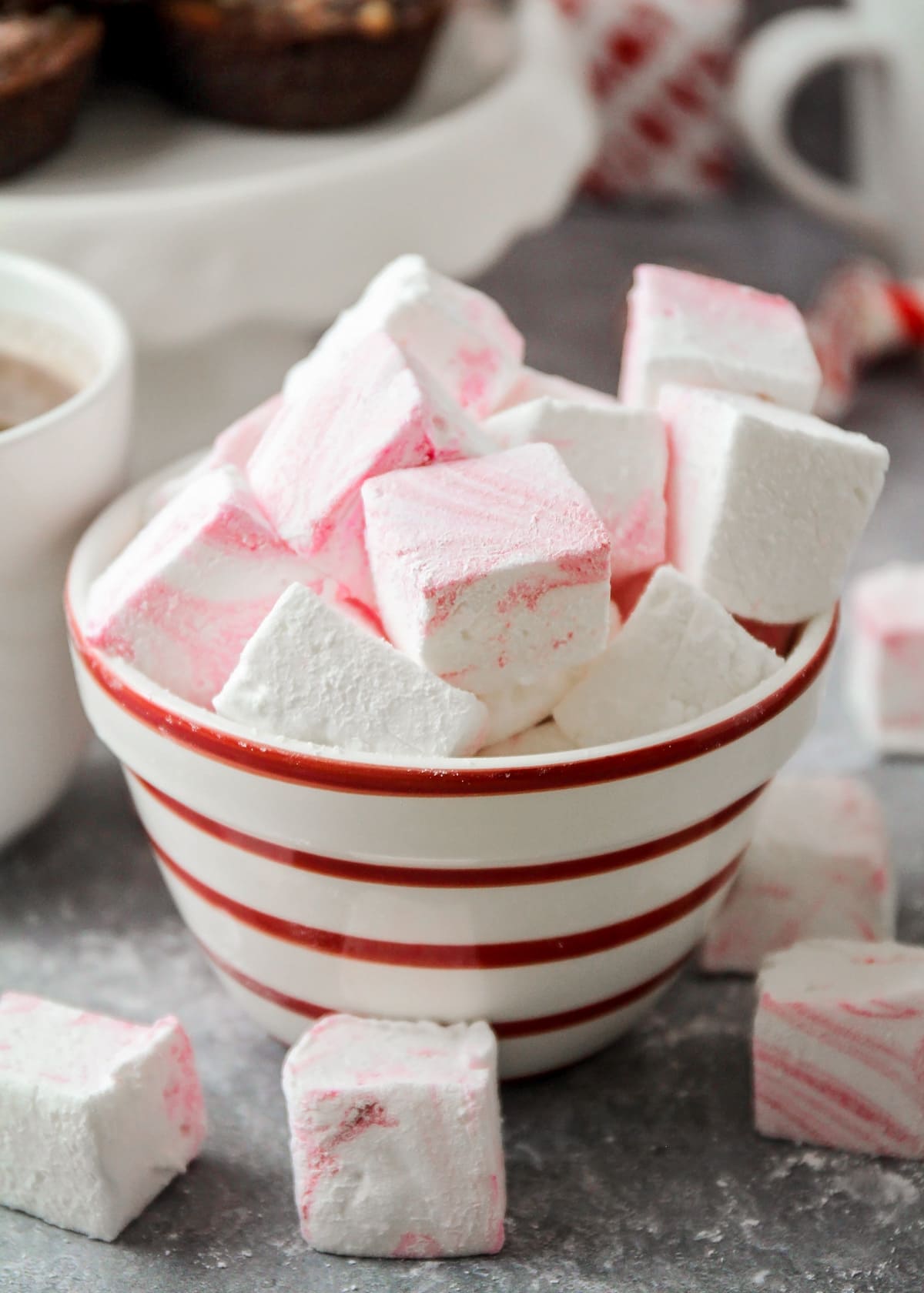 Close up of red and white bowl filled with peppermint marshmallows.