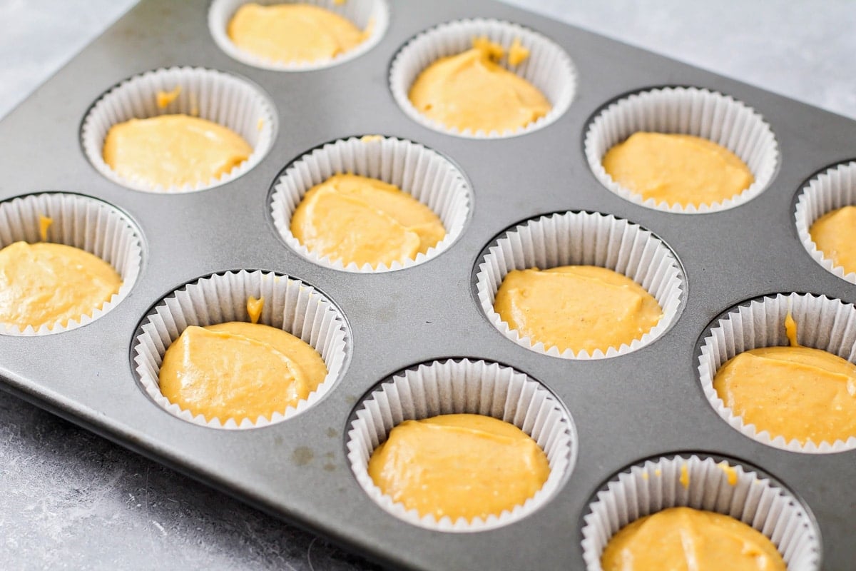 Pumpkin cupcake batter in cupcake liners.