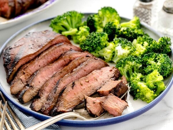 Easy steak marinade flavored steak sliced and served with broccoli.