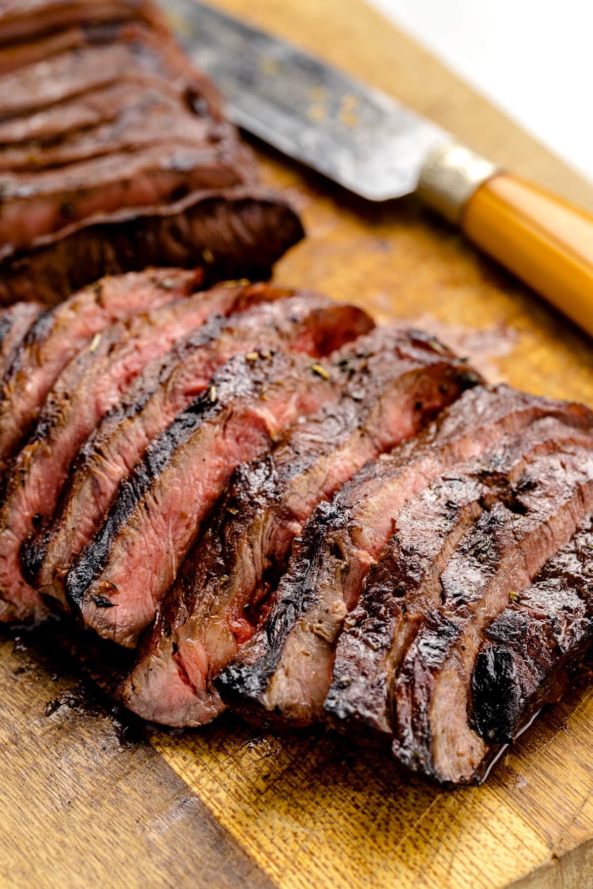 Close up of two steaks sliced on a cutting board.