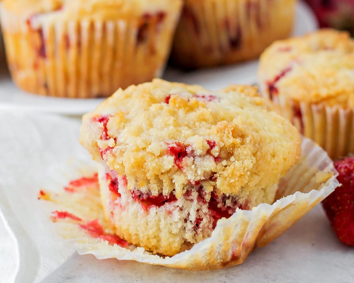 Close up of a strawberry studded muffin with the wrapper removed.