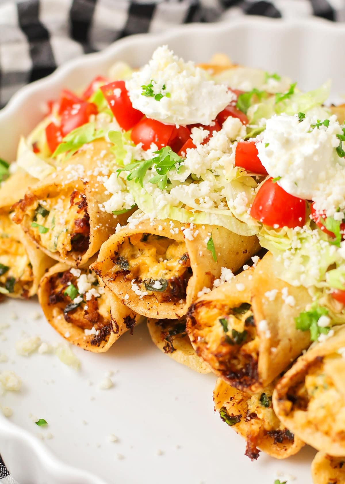 Close up image of homemade taquitos stacked on top of each other.