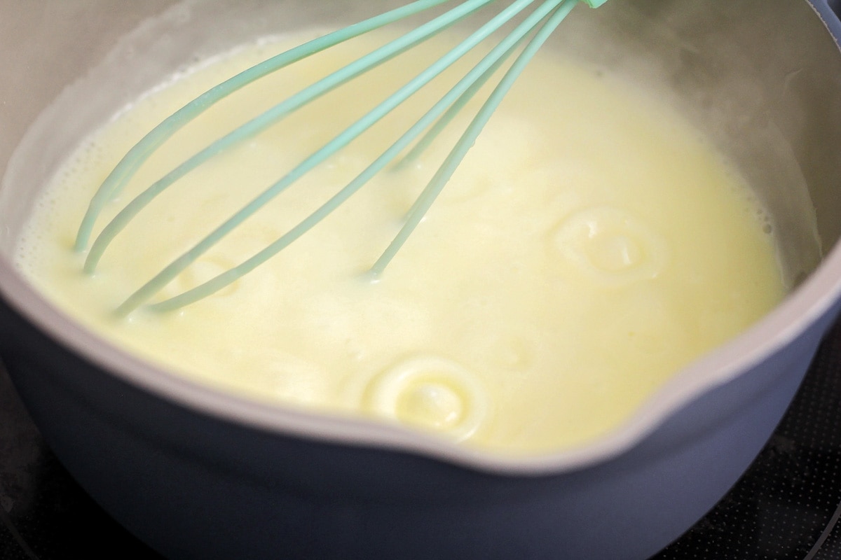 Whisking egg and milk mixture as it thickens on the stove.