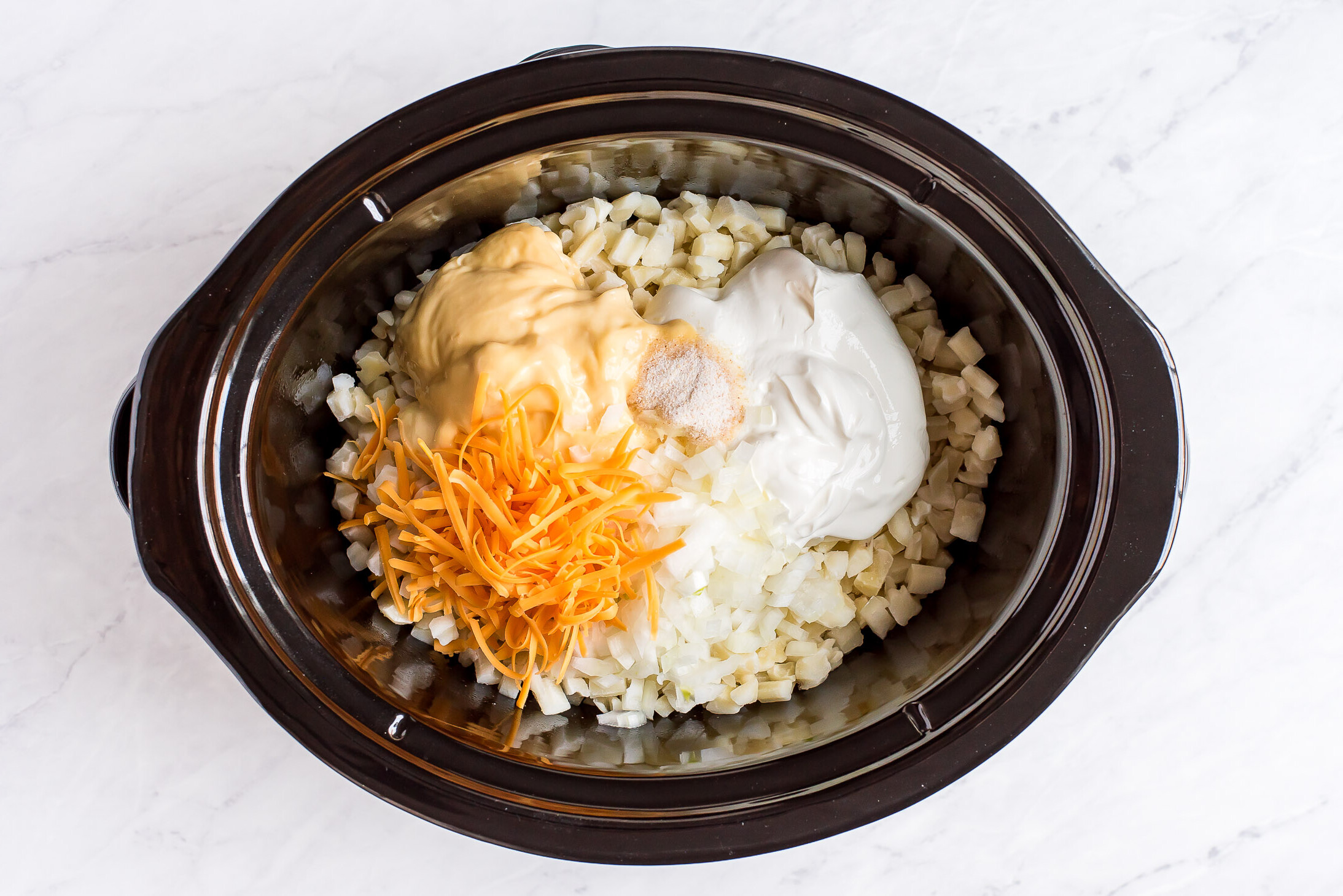 Crockpot cheesy potatoes are the perfect, easy side dish for your next meal or holiday gathering. Just dump, cook, and enjoy!! Combining hash browns, sour cream, condensed soup, and cheese in a crock pot.