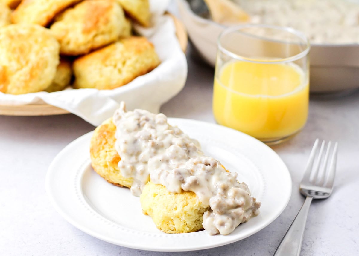 Biscuits and gravy on a white plate.