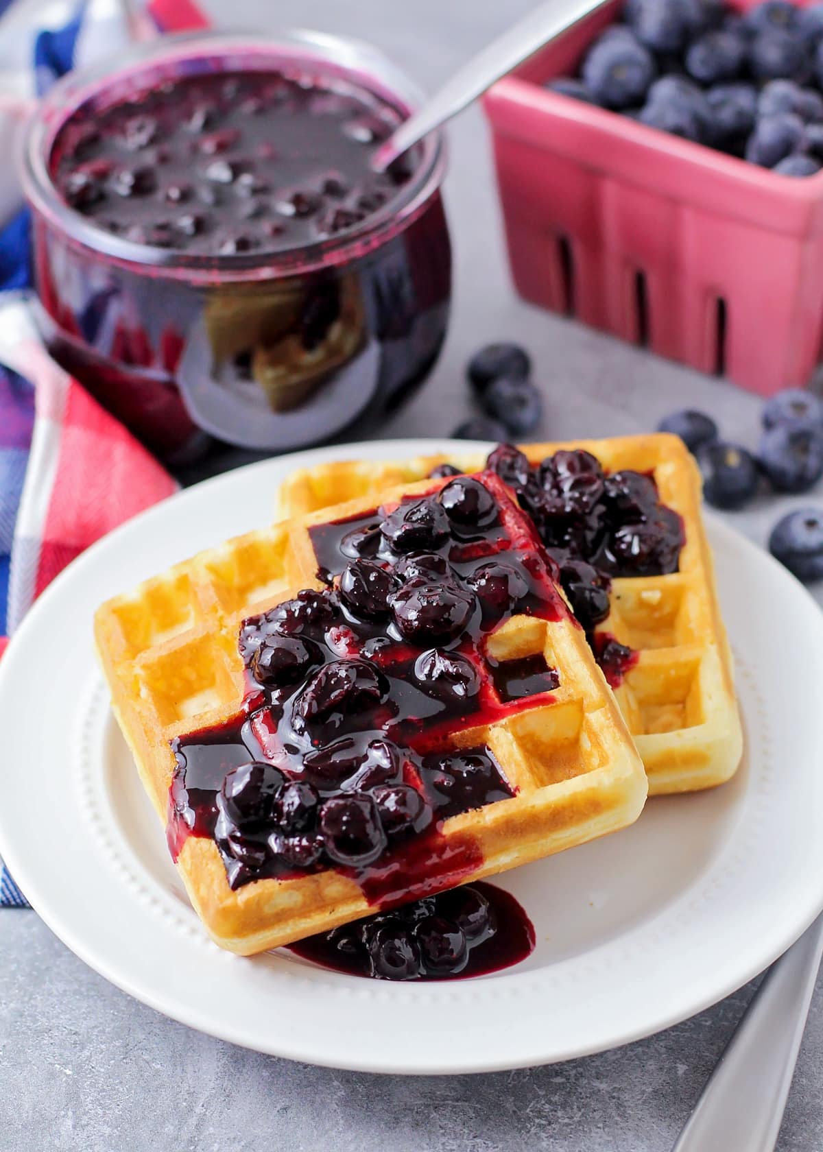 Two waffles topped with fresh blueberry sauce.