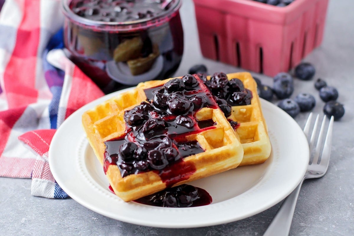 Two waffles topped with fresh blueberry sauce.