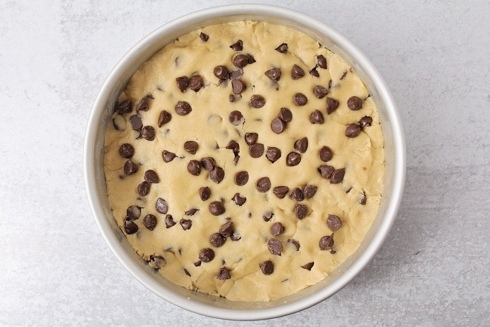 Cookie dough pressed into cake pan.
