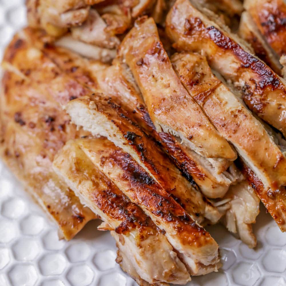 Slices of grilled Huli Huli chicken on white plate.