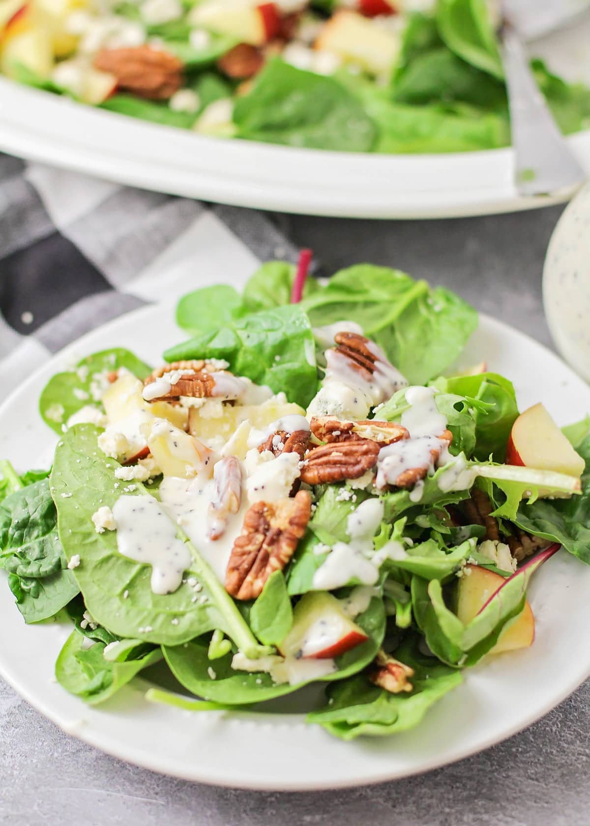 A plate apple pecan salad topped with poppyseed dressing.