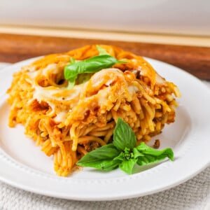 Baked spaghetti served on a white plate.