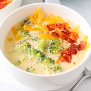 Broccoli cheese soup recipe in bowl with spoon next to it.