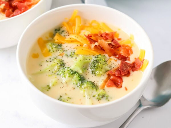 Broccoli cheese soup recipe in bowl with spoon next to it.