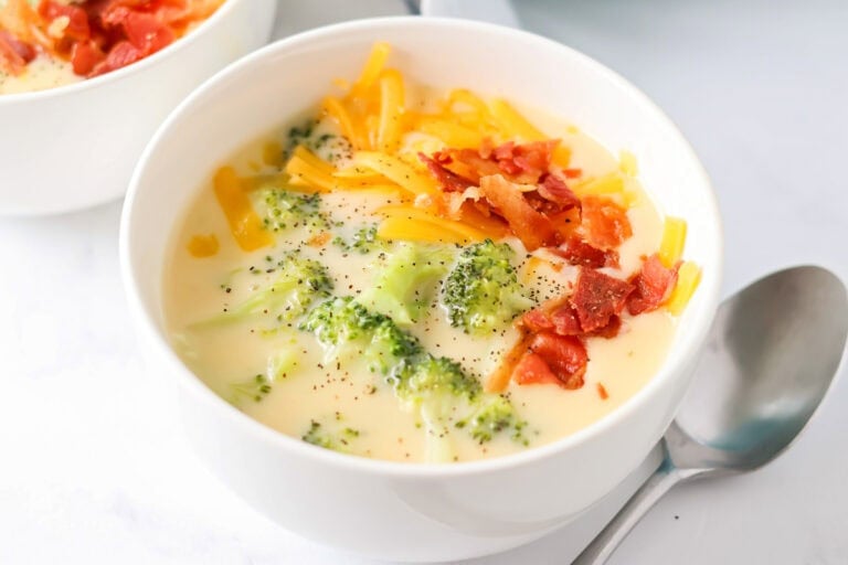 Broccoli cheese soup recipe in bowl with spoon next to it.