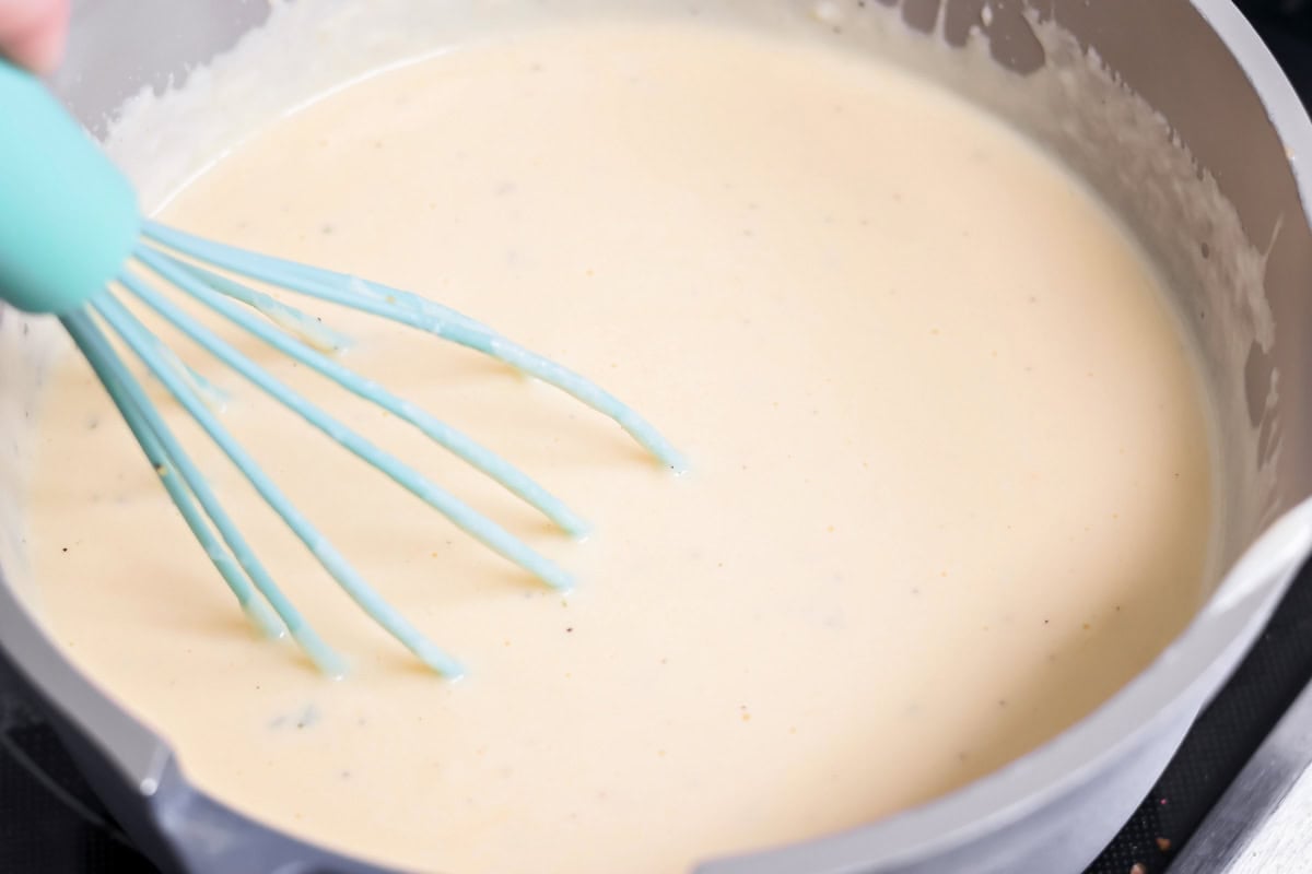 Whisking cheese in pot for broccoli cheese soup.