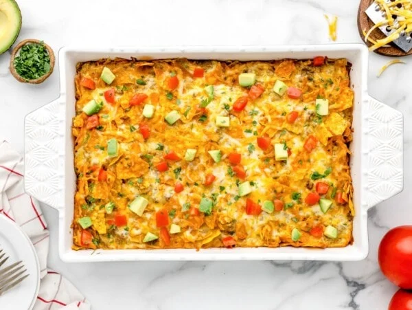 Cheesy Dorito casserole in a white baking dish.