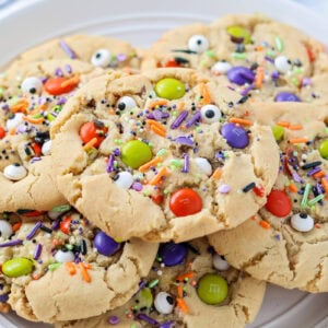 Homemade Halloween cookies stacked on white plate.