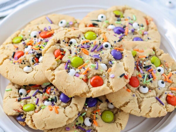 Homemade Halloween cookies stacked on white plate.