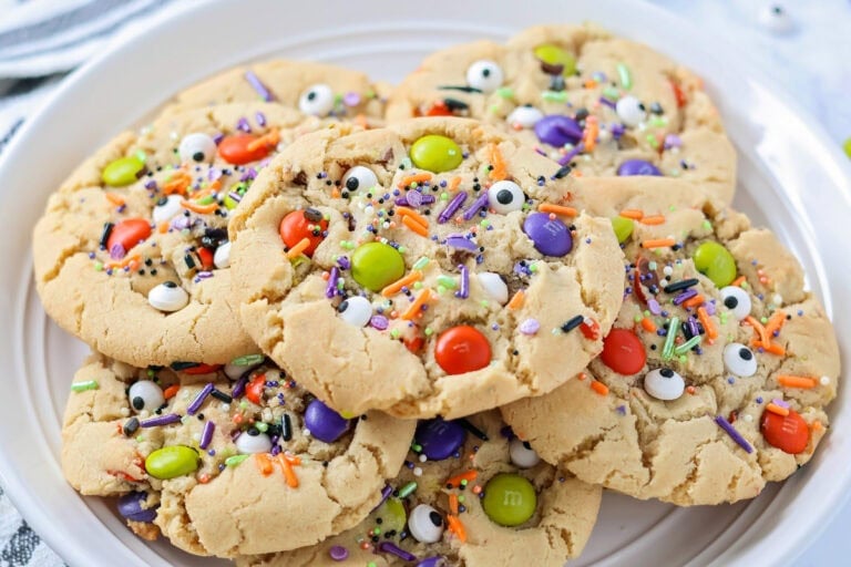 Homemade Halloween cookies stacked on white plate.