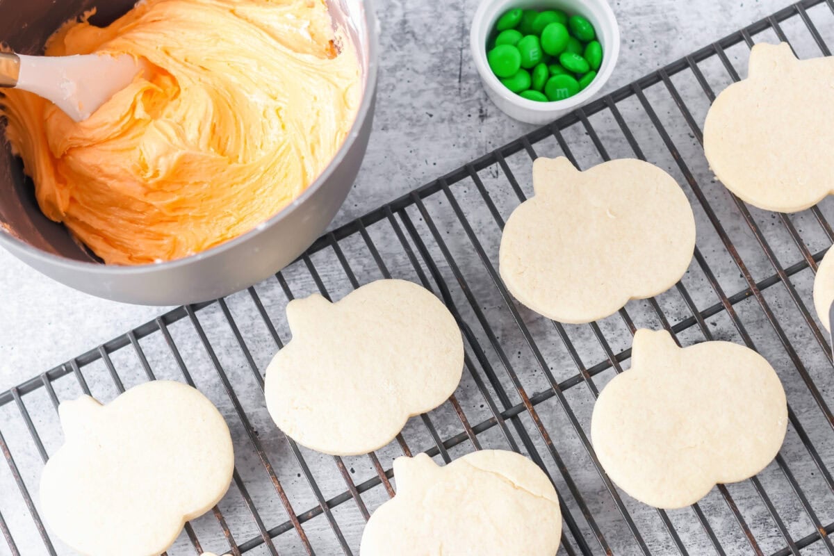 Sugar cookies about to be frosted on cookie rack.