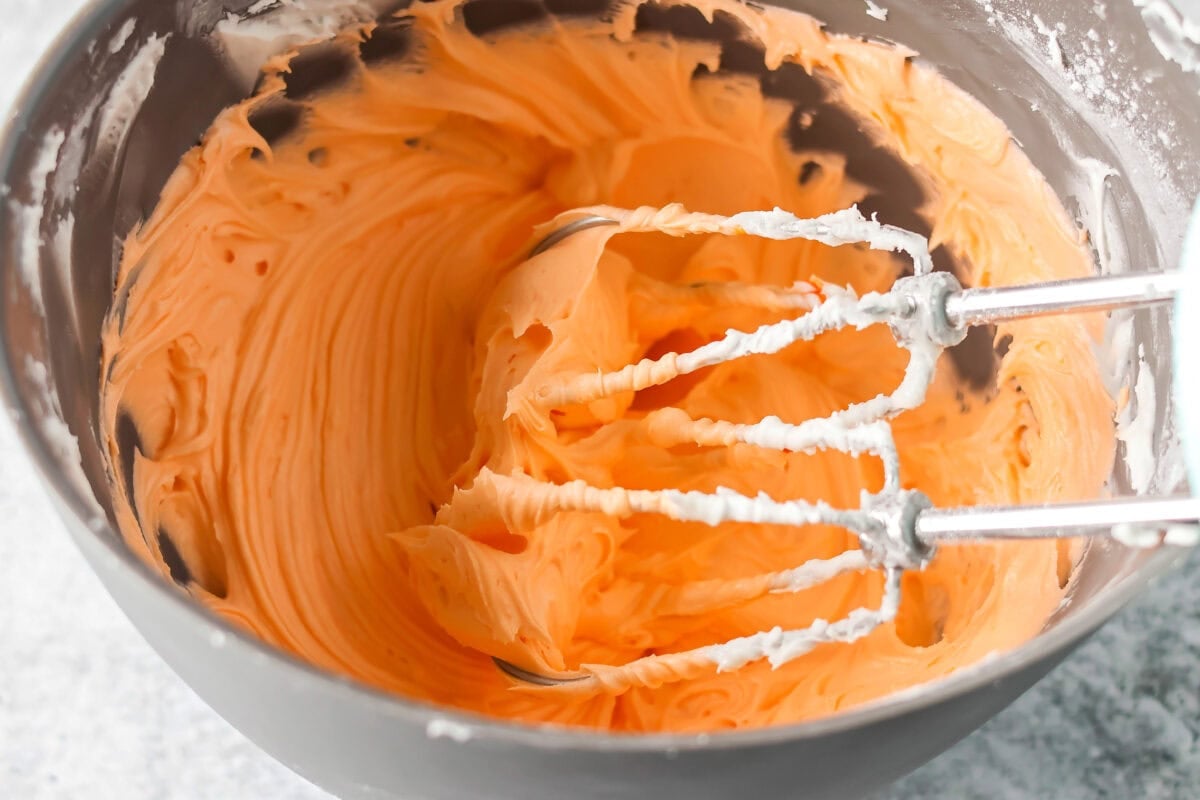 Orange frosting mixed together in bowl.