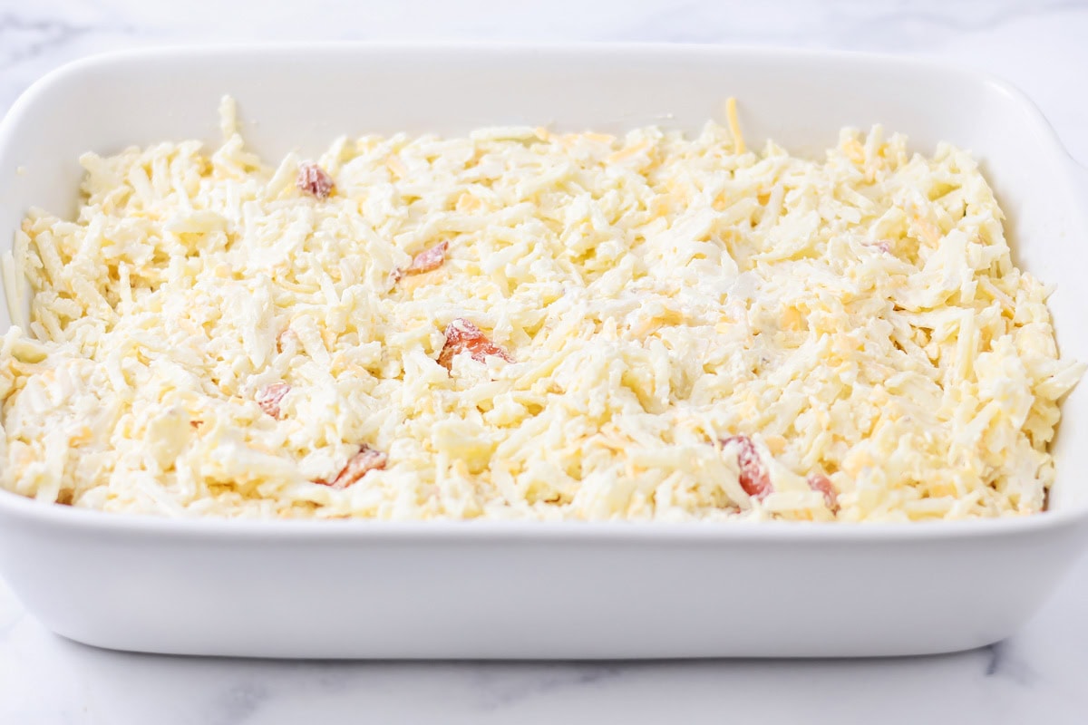 Hashbrown casserole potatoes poured into baking dish.