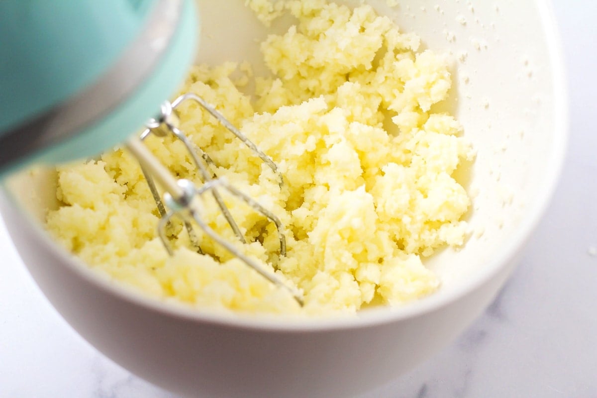 Whipping sugar into a bowl of butter.