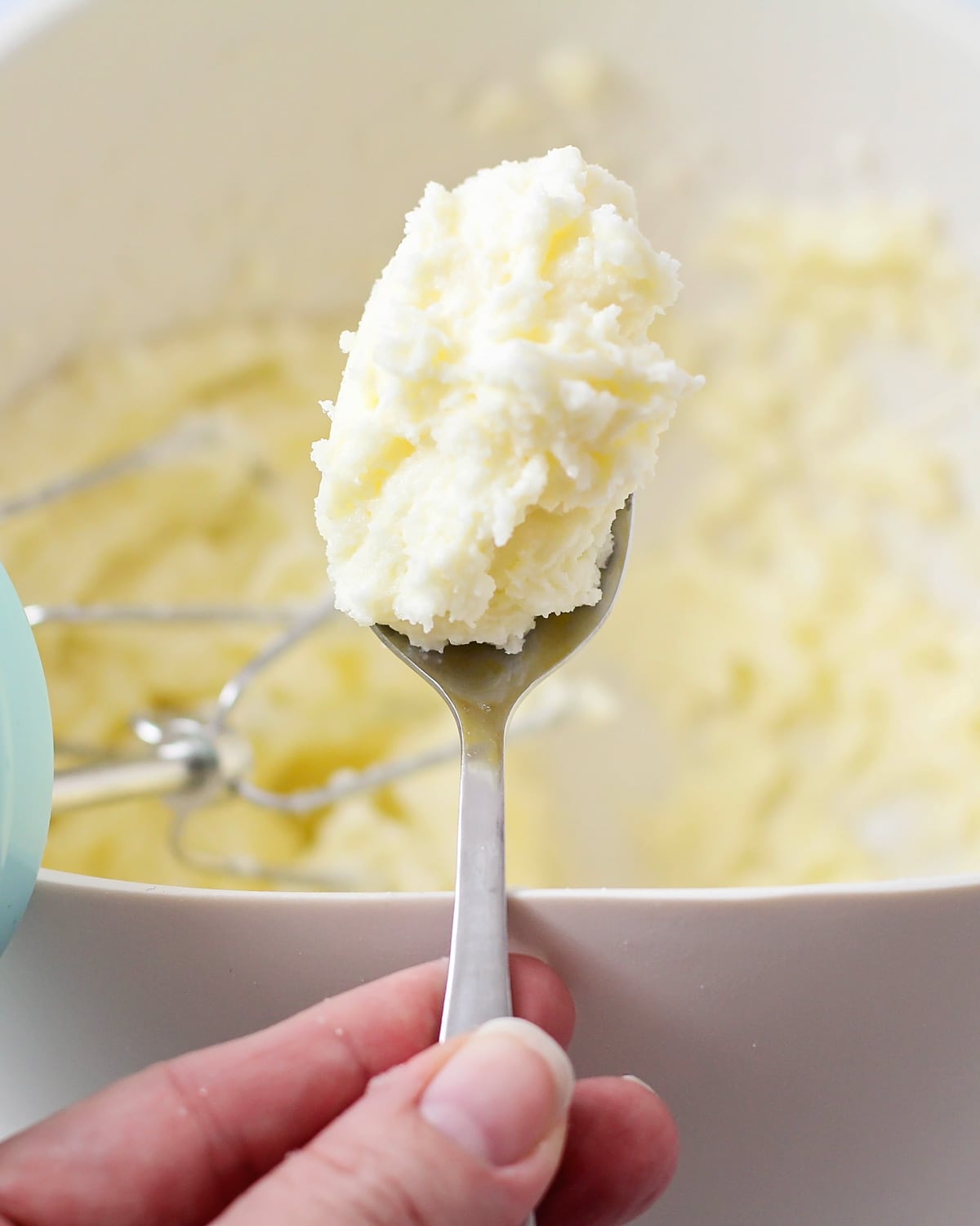 Close up of a spoon filled with butter whipped with sugar.