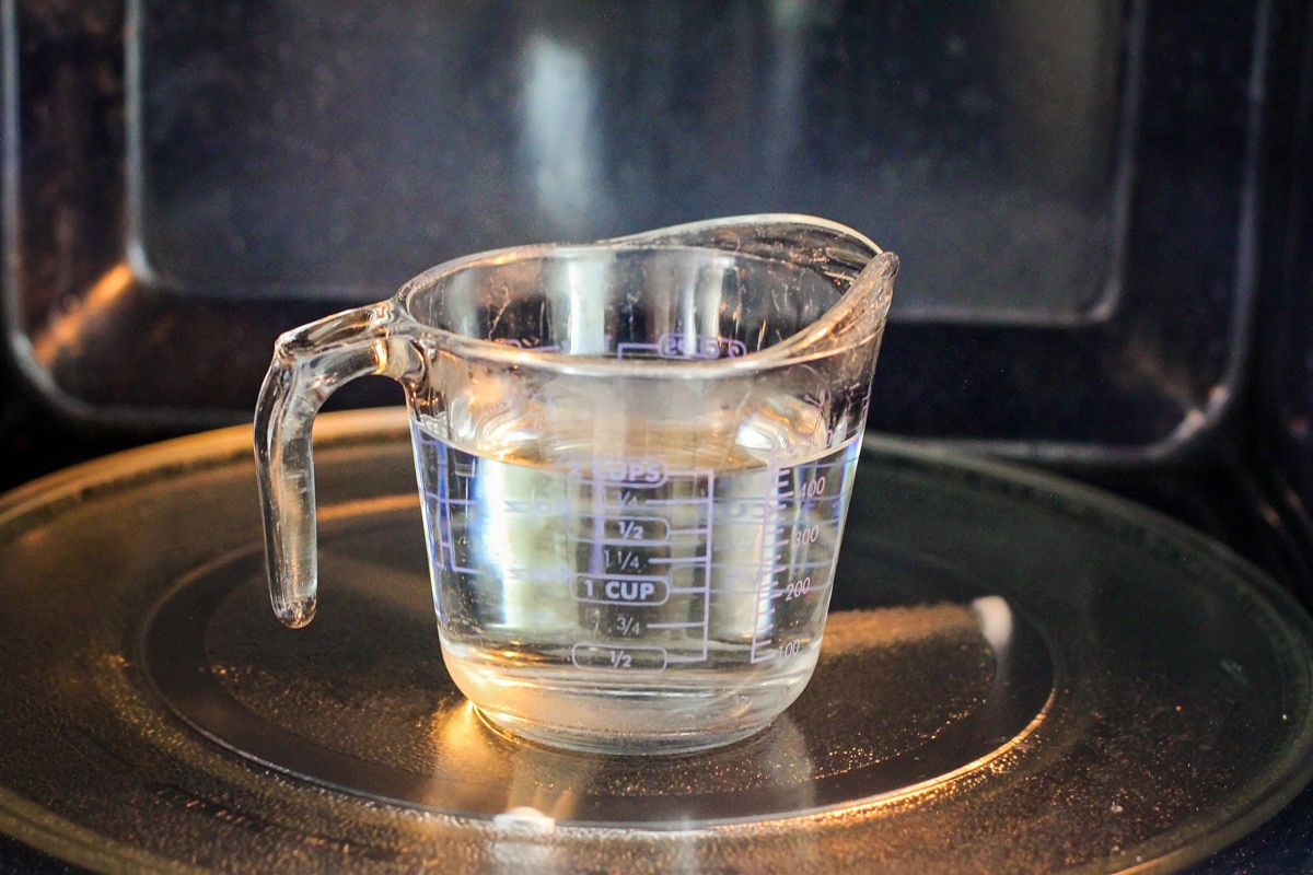 A glass of water heating in a microwave.