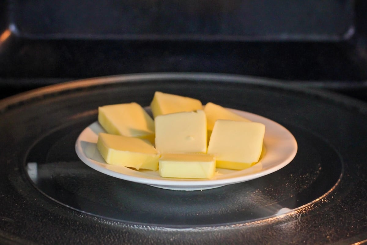 A plate of sliced butter in a microwave.
