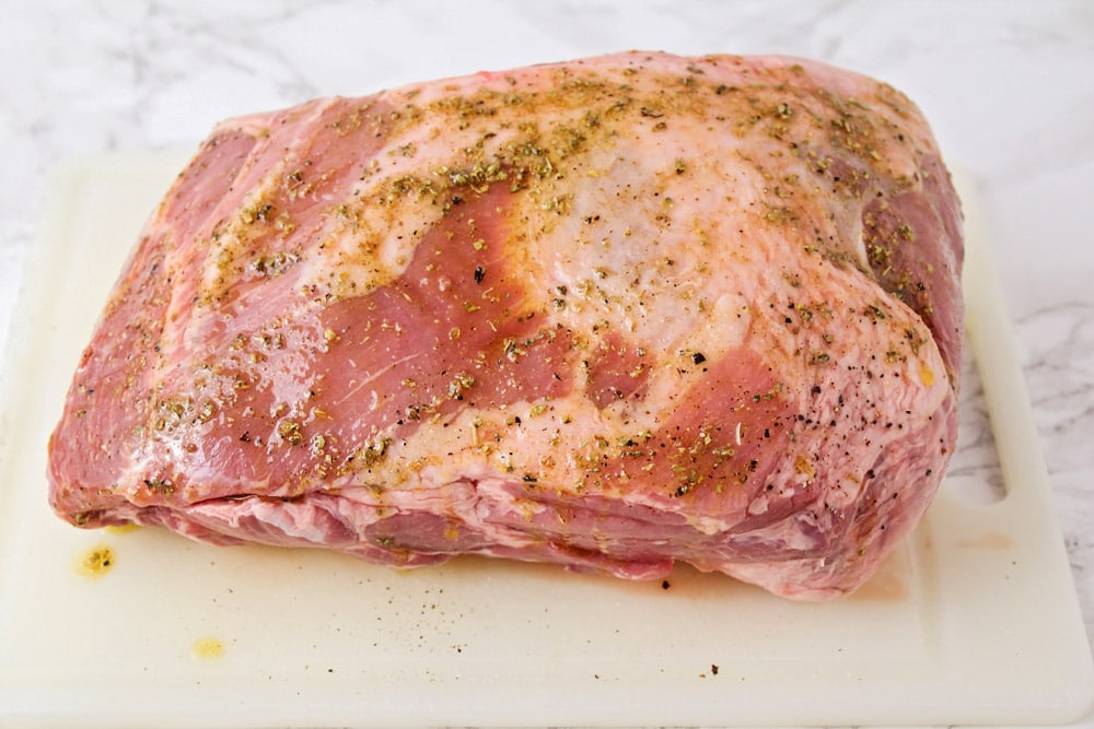 A pork shoulder covered in seasonings.