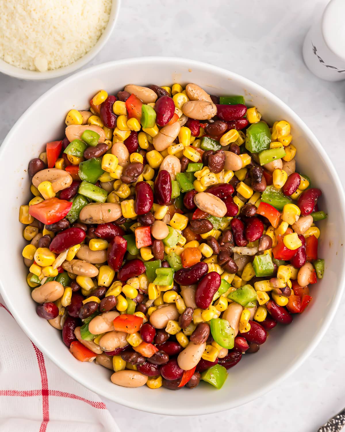 A Mexican bean salad mixed in a white bowl.