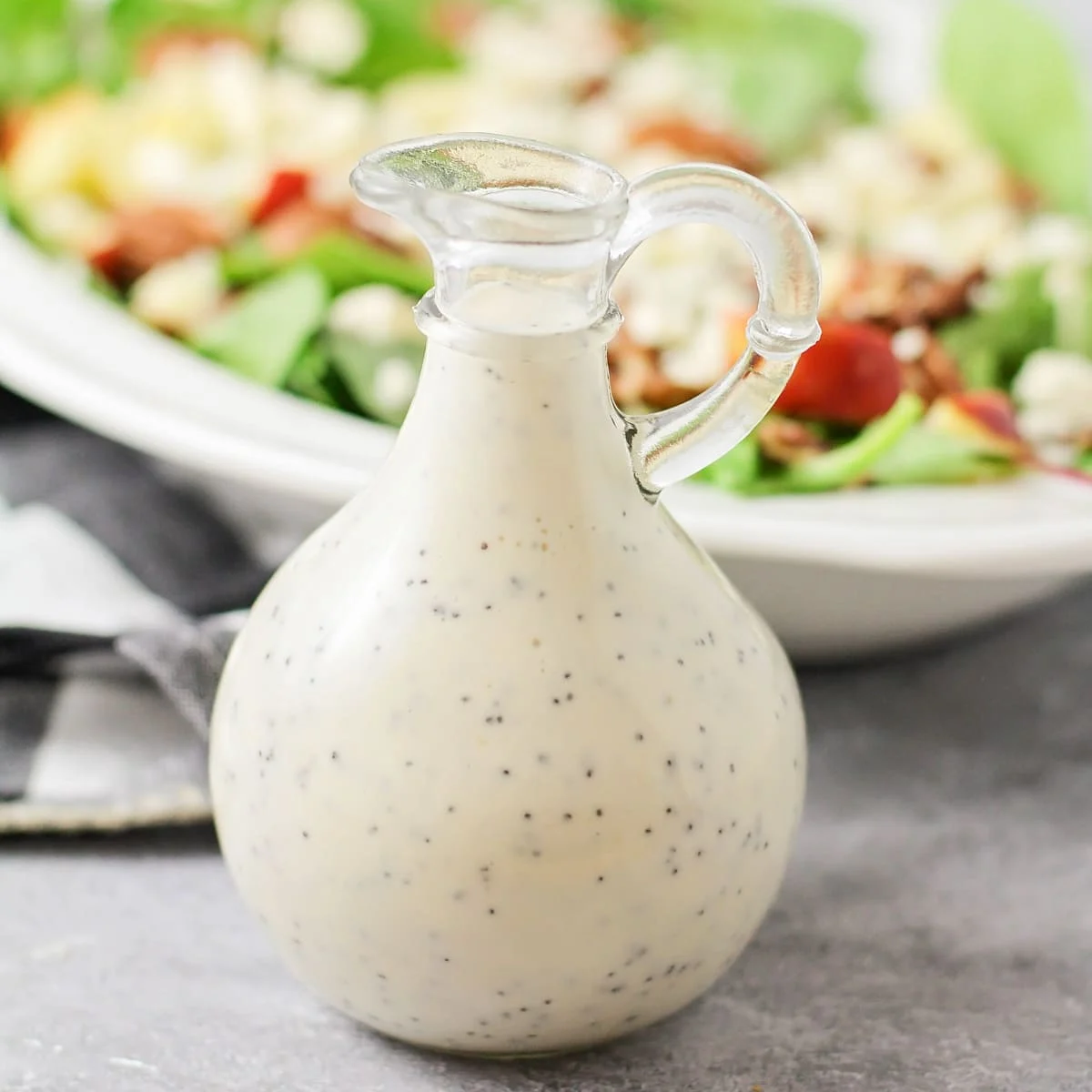A glass jar filled wtih poppyseed dressing.