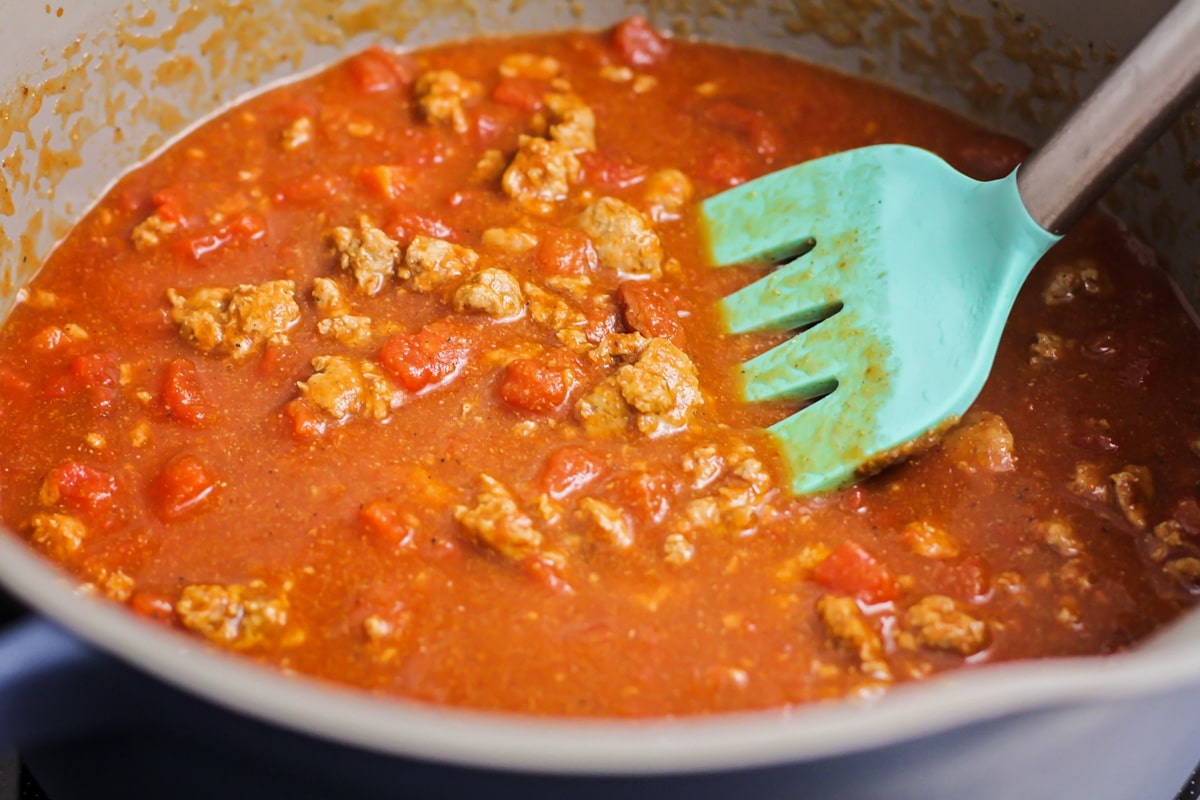 Turkey chili ingredients stirred together in pot.