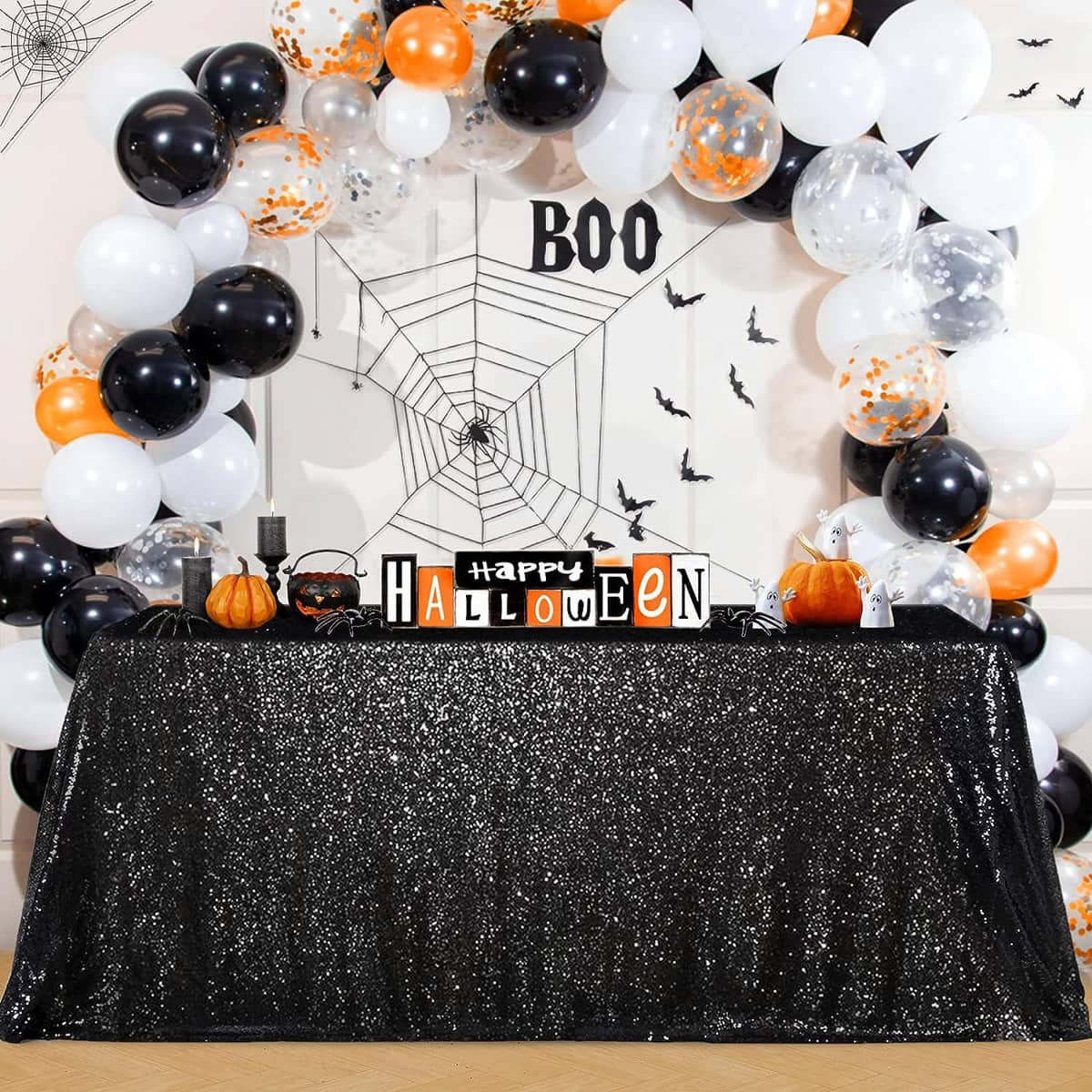 Black sequin tablecloth with Halloween balloons and decorations.