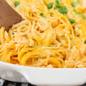 Serving chicken spaghetti from a casserole dish.