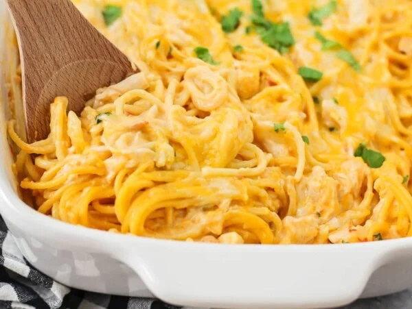 Serving chicken spaghetti from a casserole dish.